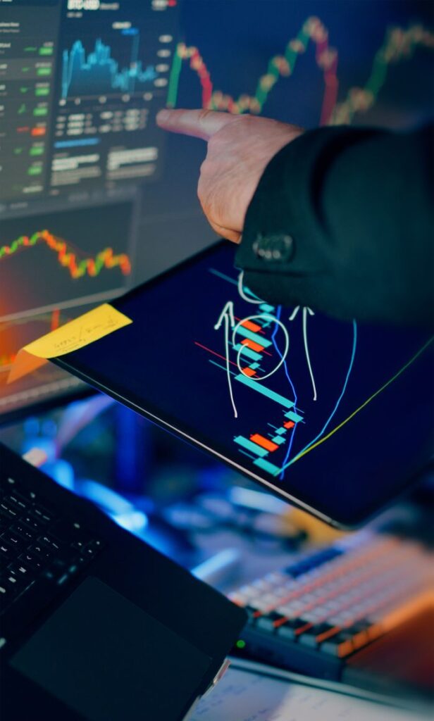 pexels photo 35638668 A business professional examines financial charts on a tablet and monitor for investment strategy.